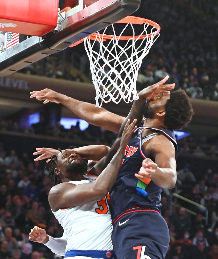 El alero de los Knicks Julius Randle es detenido por el jugador de los 76ers Joel Embiid durante la primera mitad de un partido el domingo 27 de febrero de 2022 en el Madison Square Garden.