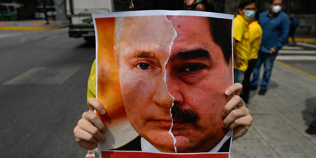 Primero Justicia sostiene un cartel que muestra el rostro del presidente ruso, Vladimir Putin, y el presidente venezolano, Nicolás Maduro. 